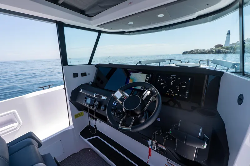 Slide: The Image of Interior view of 2026 Axopar 29 Cross Cabin boat with modern dashboard and ocean backdrop. - 32