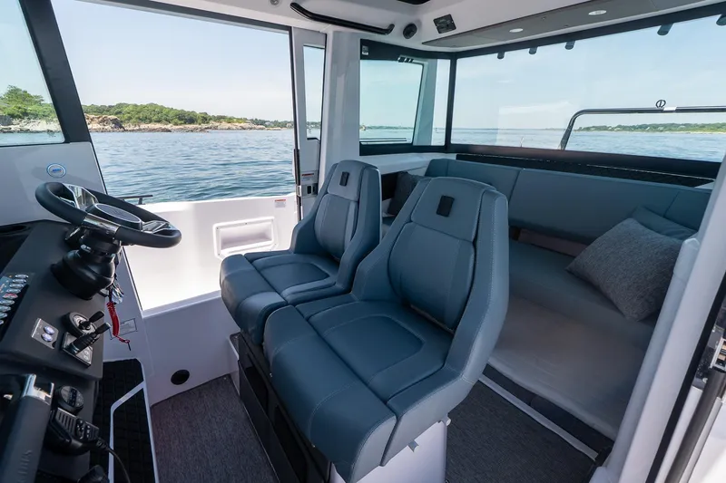 Slide: The Image of 2026 Axopar 29 Cross Cabin interior with modern seating and scenic ocean view. - 38