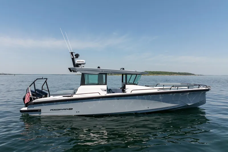 Slide: The Image of 2026 Axopar 29 Cross Cabin boat on calm water, side view. - 5