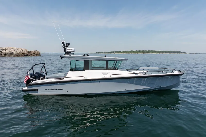Slide: The Image of 2026 Axopar 29 Cross Cabin boat on calm water, clear sky background. - 8