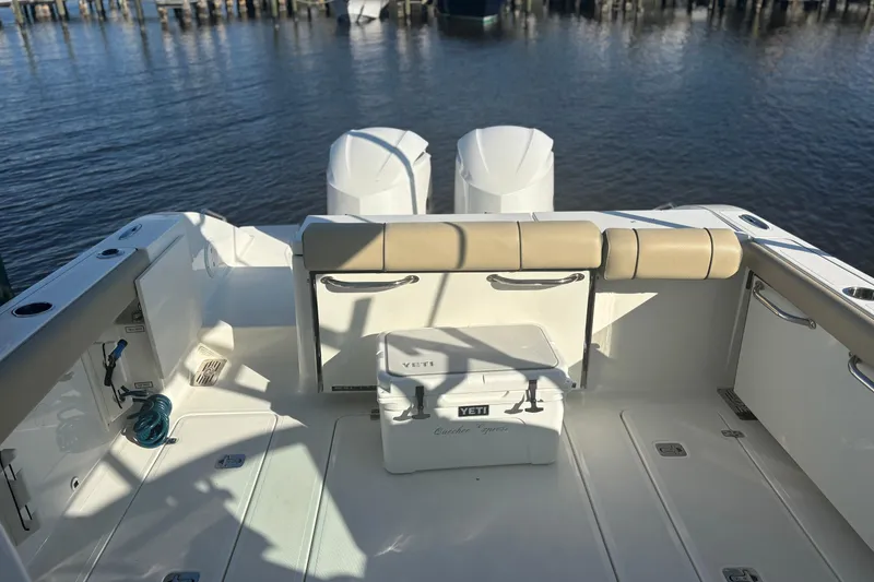 Slide: The Image of 2020 Pursuit DC 295 Dual Console boat with twin engines and Yeti cooler on deck. - 12