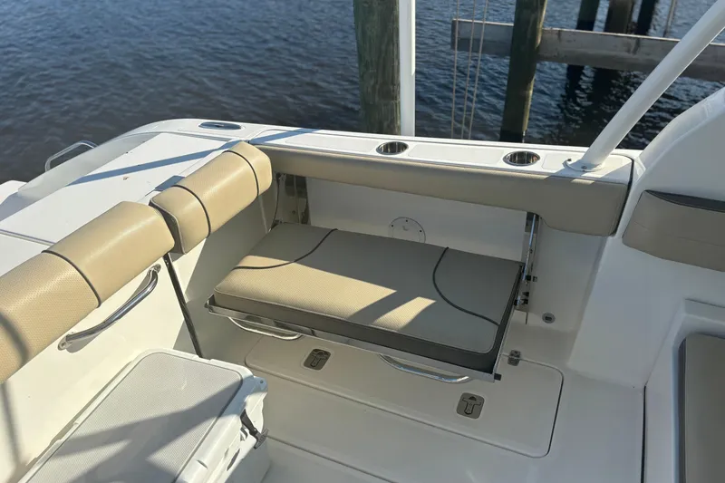 Slide: The Image of 2020 Pursuit DC 295 Dual Console boat interior with beige seating and cup holders. - 14