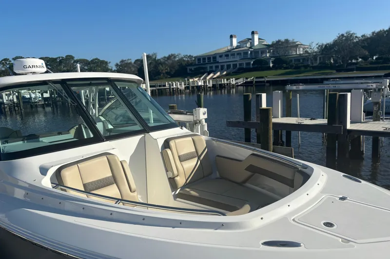 Slide: The Image of 2020 Pursuit DC 295 Dual Console boat docked near a waterfront property. - 4
