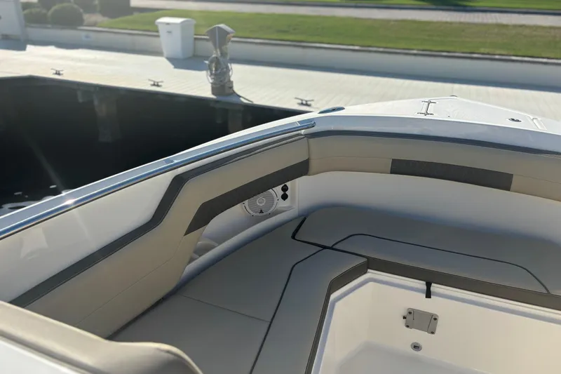 Slide: The Image of 2020 Pursuit DC 295 Dual Console boat interior with cushioned seating and speaker. - 6