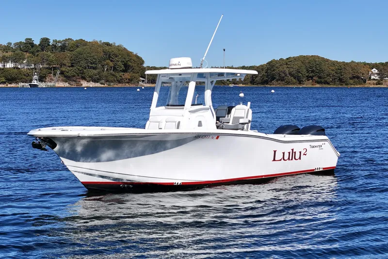 The Image of 2018 Tidewater 280 CC Adventure boat on calm water, featuring dual engines and sleek design. - 0