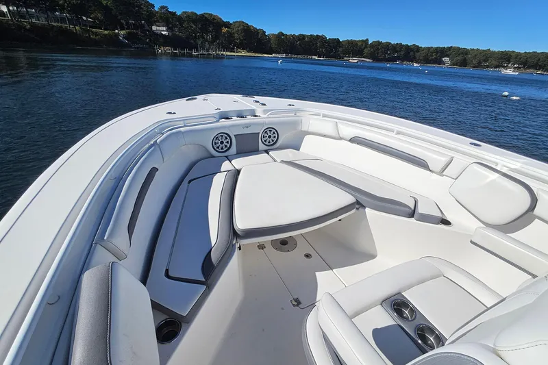 Slide: The Image of 2018 Tidewater 280 CC Adventure boat interior with cushioned seating on a sunny day. - 19