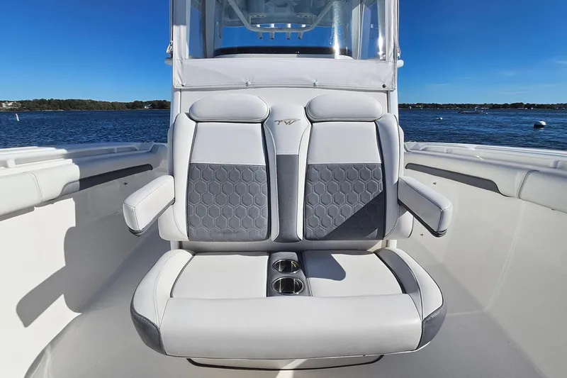Slide: The Image of 2018 Tidewater 280 CC Adventure boat with cushioned seating and cup holders on a sunny day. - 21