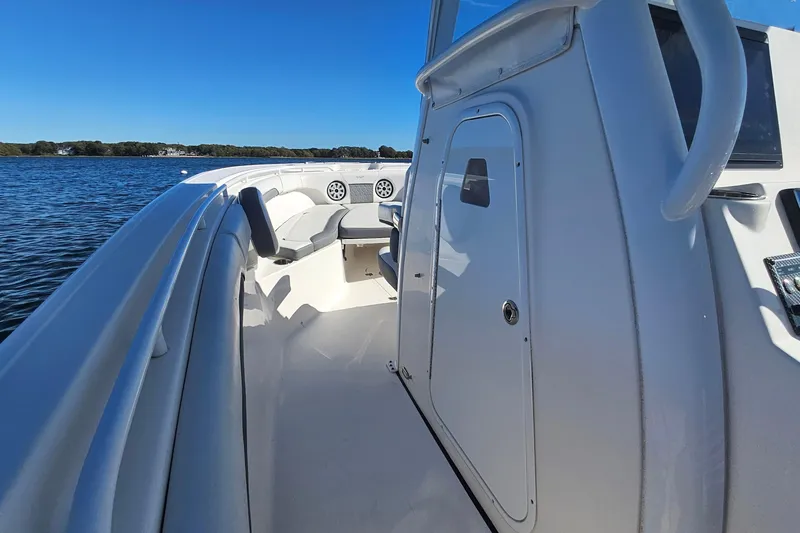 Slide: The Image of 2018 Tidewater 280 CC Adventure boat on calm water, featuring sleek design and spacious seating. - 23