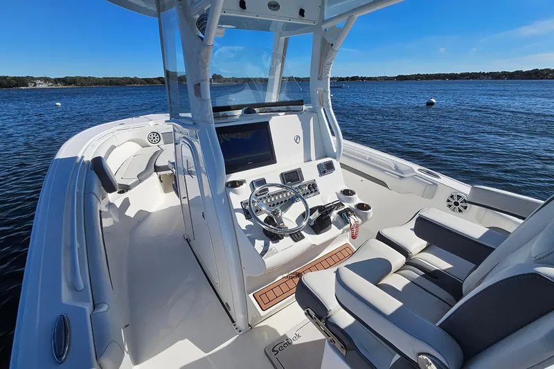 Slide: The Image of 2018 Tidewater 280 CC Adventure boat interior with steering console on a sunny day. - 25