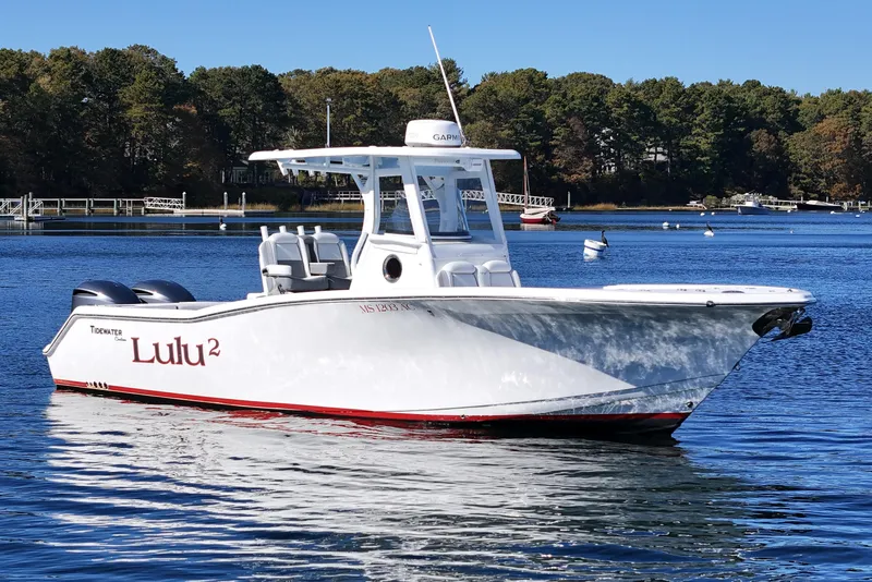 Slide: The Image of 2018 Tidewater 280 CC Adventure boat on calm water with scenic background. - 3