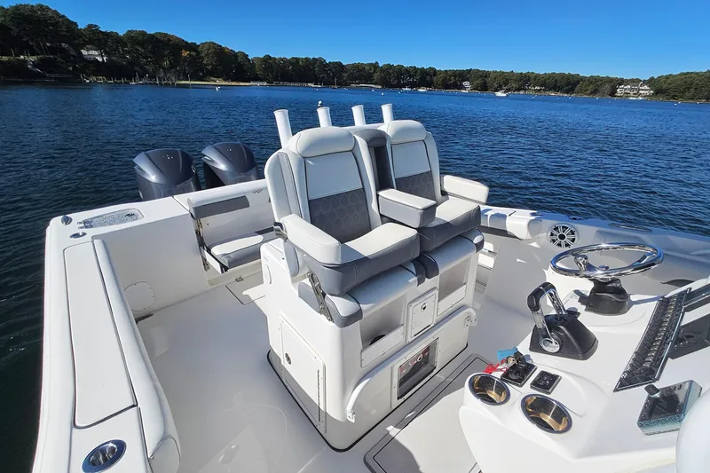 Slide: The Image of 2018 Tidewater 280 CC Adventure boat interior with dual seats and steering console on a sunny day. - 34
