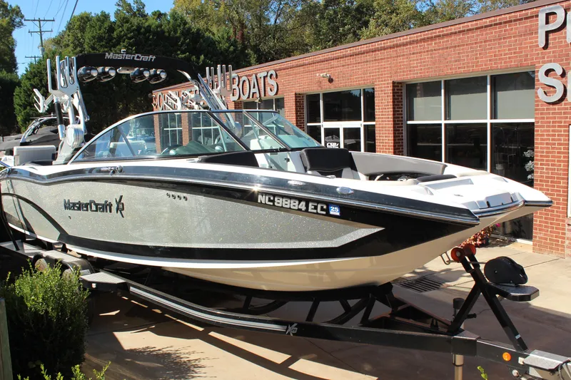 The Image of 2016 MasterCraft X26 boat displayed outside a brick building. - 1