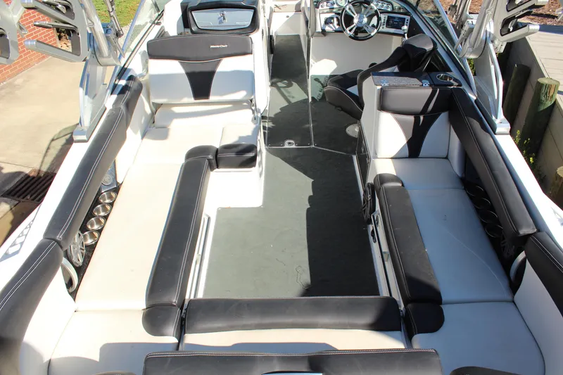 Slide: The Image of 2016 MasterCraft X26 boat interior with black and white seating and modern dashboard. - 10