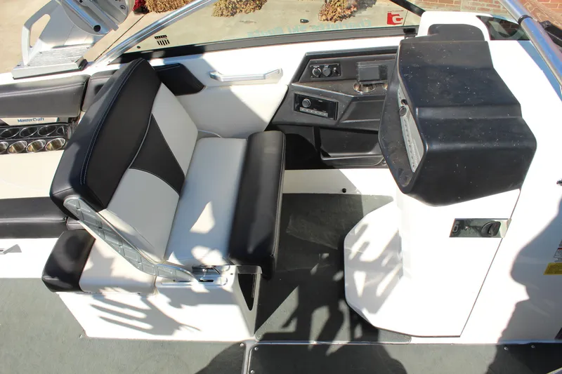 Slide: The Image of 2016 MasterCraft X26 boat interior with black and white seating and control panel. - 15