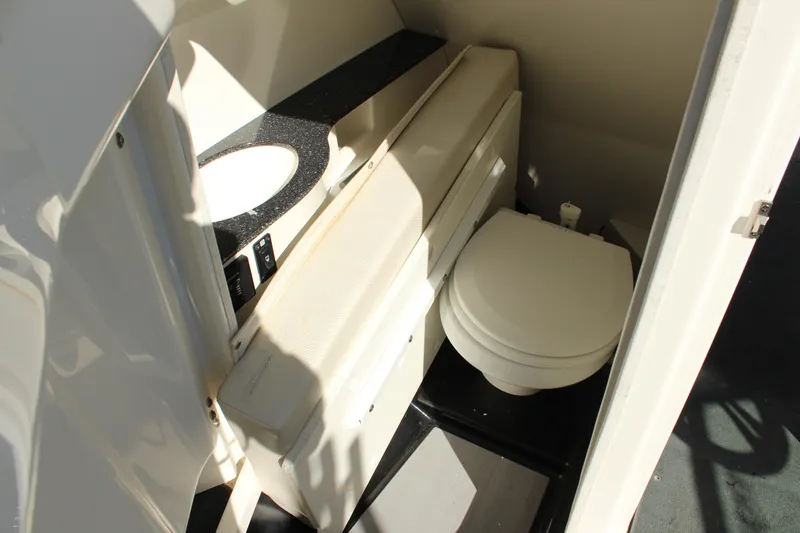 Slide: The Image of 2016 MasterCraft X26 boat interior bathroom with toilet and sink. - 16