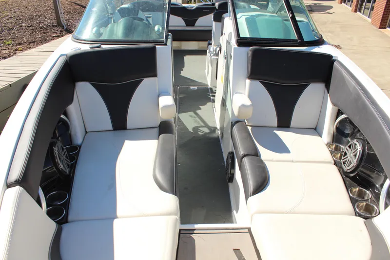 Slide: The Image of 2016 MasterCraft X26 boat interior with black and white seating and cup holders. - 18