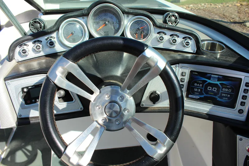 Slide: The Image of Steering wheel and dashboard of a 2016 MasterCraft X26 boat, featuring modern gauges and controls. - 19