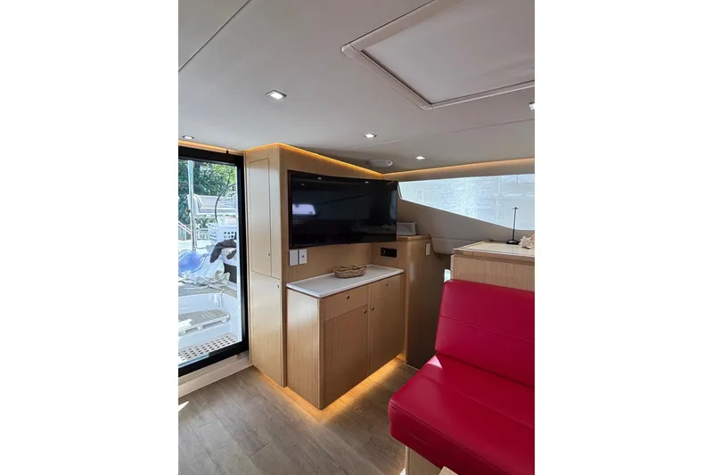 Slide: The Image of Luxurious interior of 2022 Seawind 1600 catamaran with modern wood finish and red seating. - 12