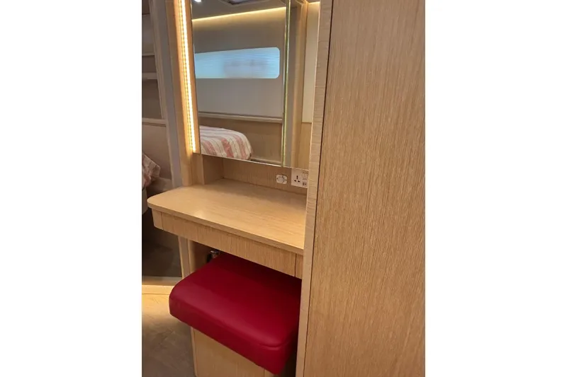 Slide: The Image of Luxurious Seawind 1600 yacht interior with vanity, mirror, and red cushioned stool, 2022 model. - 17