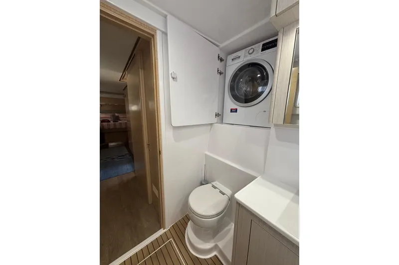 Slide: The Image of Seawind 1600 2022 yacht bathroom with toilet and washer-dryer combo. - 22