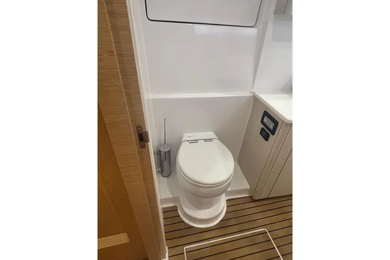Slide: The Image of 2022 Seawind 1600 yacht bathroom with modern toilet and wooden flooring. - 27