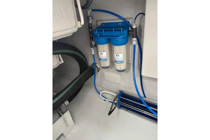 Slide: The Image of Water filtration system in a 2022 Seawind 1600 yacht, featuring dual filters and blue tubing. - 38