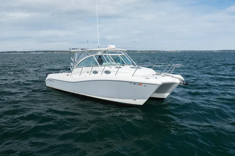 The Image of 2017 World Cat 320 EC boat cruising on open water under a cloudy sky. - 0