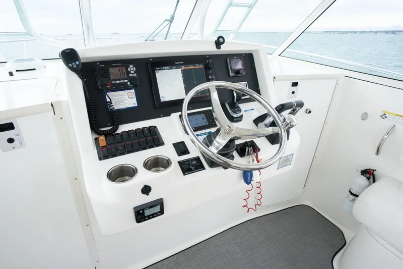 Slide: The Image of Helm of 2017 World Cat 320 EC boat with steering wheel and navigation controls. - 24