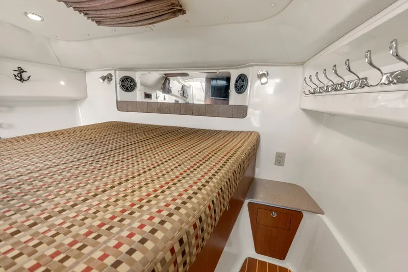 Slide: The Image of 2017 World Cat 320 EC cabin interior with bed, storage, and nautical decor. - 28