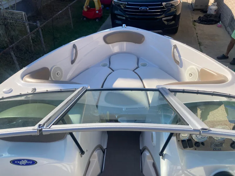 Slide: The Image of 2008 Four Winns 180 Horizon boat interior with seating and windshield, parked in driveway. - 12