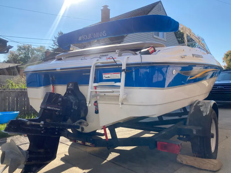 Slide: The Image of 2008 Four Winns 180 Horizon boat on trailer, blue and white design, MerCruiser engine. - 19