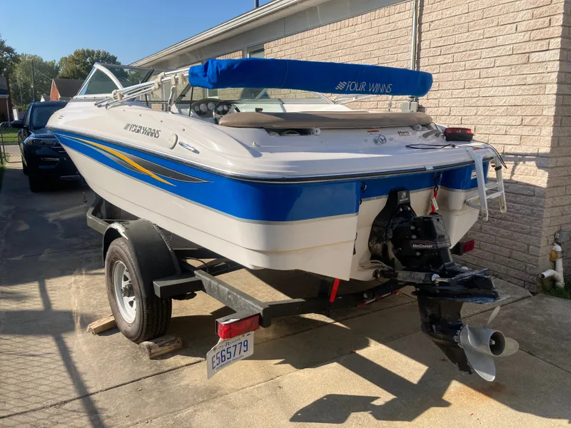 Slide: The Image of 2008 Four Winns 180 Horizon boat on trailer, blue and white design, parked outdoors. - 20