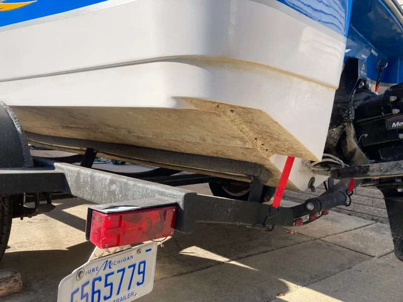 Slide: The Image of 2008 Four Winns 180 Horizon boat on trailer, showing hull and Michigan license plate. - 25