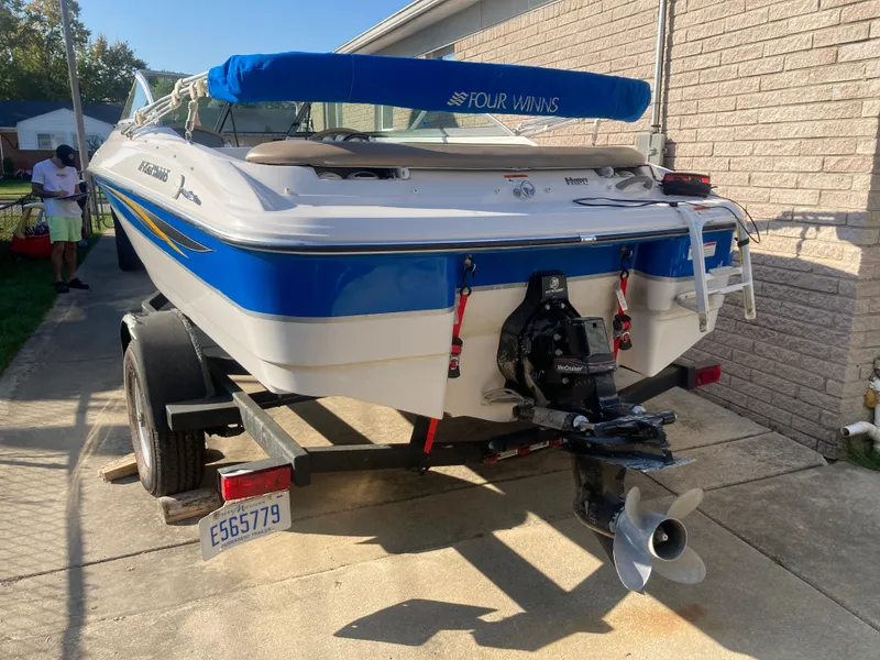 Slide: The Image of 2008 Four Winns 180 Horizon boat on trailer, blue and white design, parked near brick wall. - 4