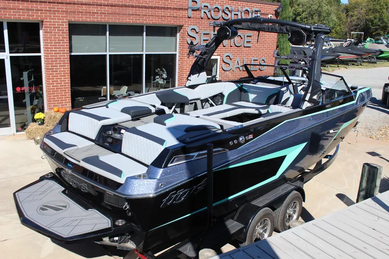 Slide: The Image of 2023 Tigé 24RZX boat with sleek design, parked outside a service and sales shop. - 5