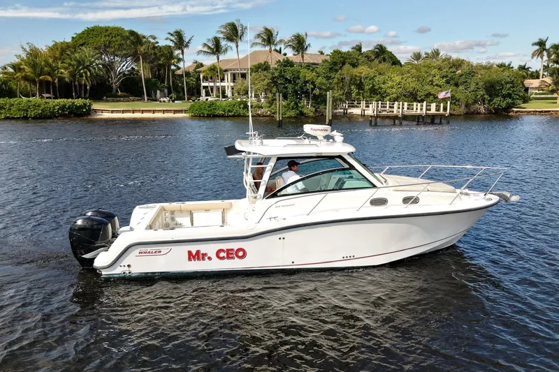 The Image of 2015 Boston Whaler 315 Conquest boat named "Mr. CEO" cruising on a scenic waterway. - 0