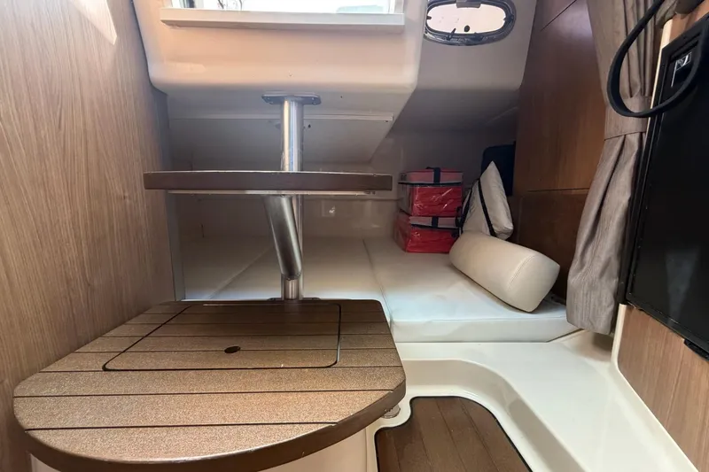 Slide: The Image of Interior cabin of 2015 Boston Whaler 315 Conquest with wooden table and seating. - 15