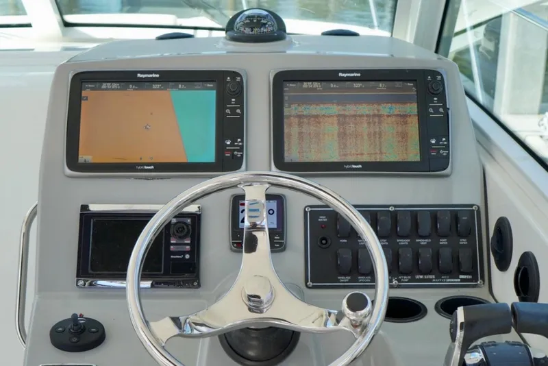 Slide: The Image of 2015 Boston Whaler 315 Conquest helm with dual Raymarine displays and steering wheel. - 22