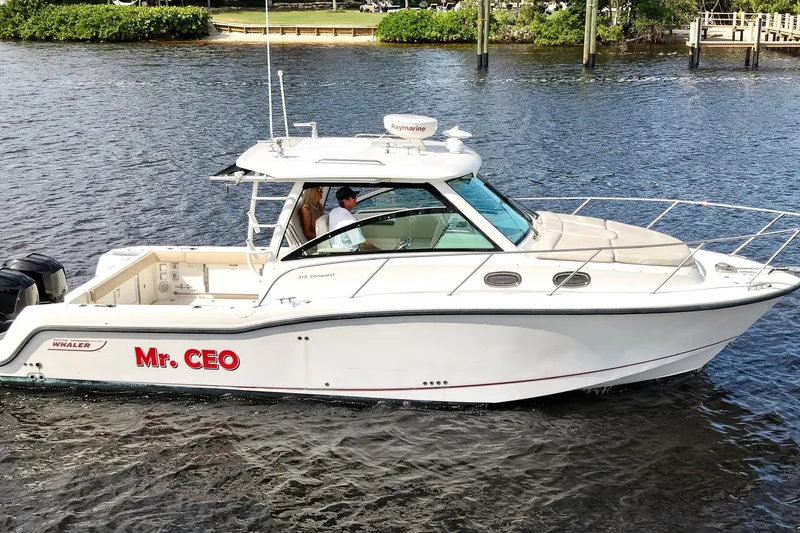 Slide: The Image of 2015 Boston Whaler 315 Conquest boat named "Mr. CEO" cruising on water. - 39