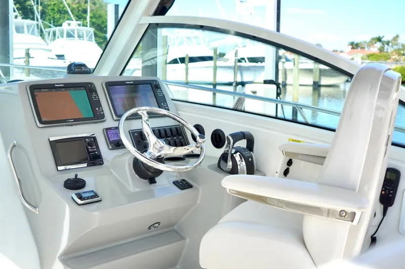Slide: The Image of 2015 Boston Whaler 315 Conquest helm with modern navigation equipment and comfortable seating. - 4