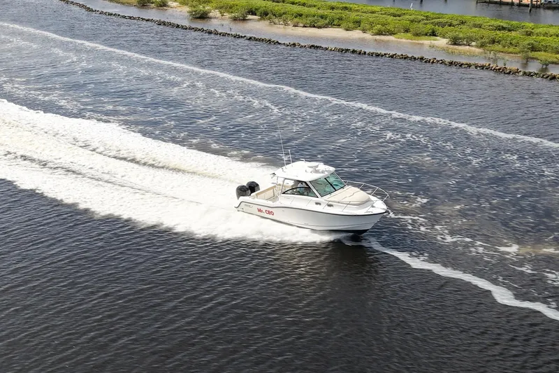 Slide: The Image of 2015 Boston Whaler 315 Conquest cruising on a scenic waterway. - 43