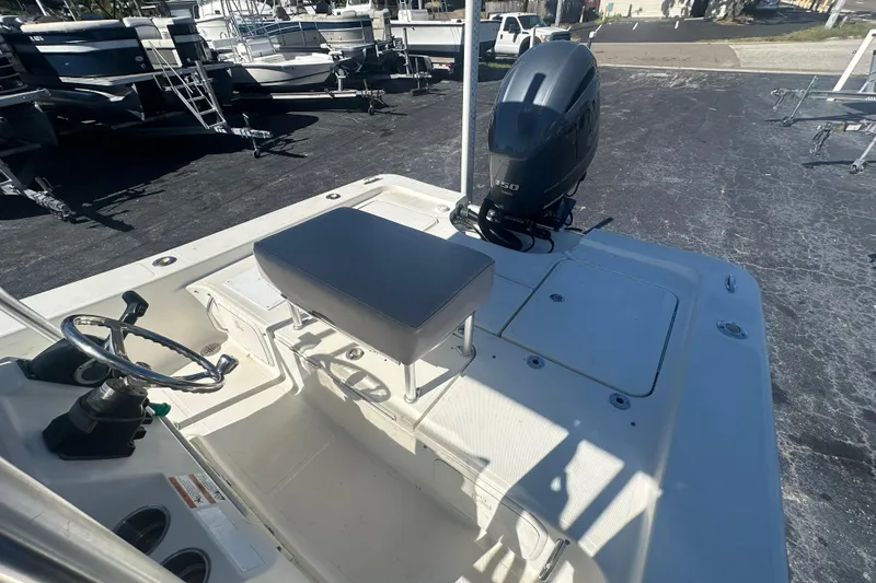 Slide: The Image of 2003 Hydra-Sports 19 Bay Bolt boat with steering wheel and outboard motor in a marina. - 16