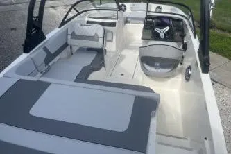 Slide: The Image of 2023 Bayliner VR5 Bowrider OB on trailer, blue and white, parked outdoors. - 6