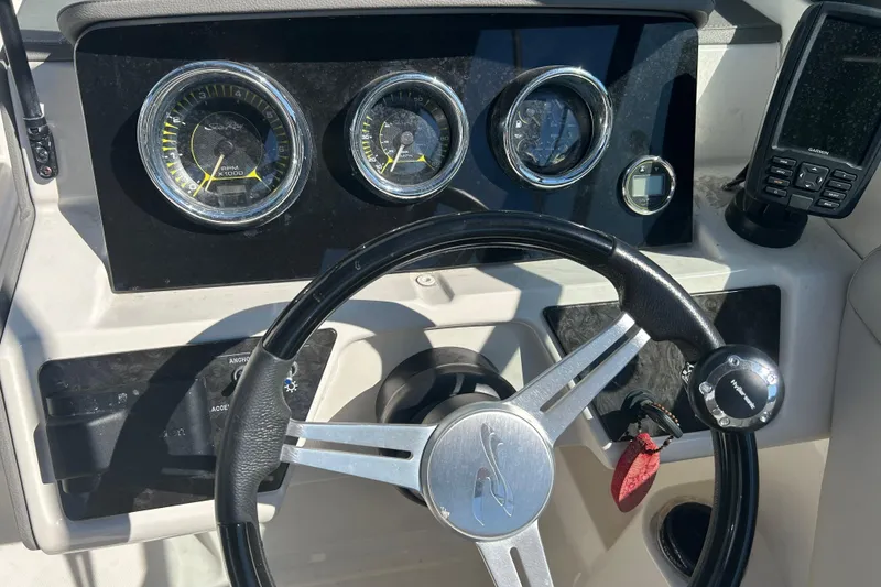 Slide: The Image of 2020 Sea Ray SPX 230 Outboard dashboard with steering wheel and gauges. - 12