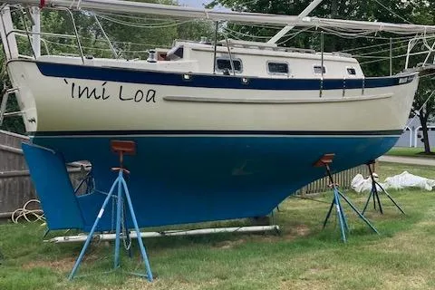 Slide: The Image of 2003 Pacific Seacraft Dana 24 sailboat on stands, named 'Imi Loa, with blue hull and white deck. - 6