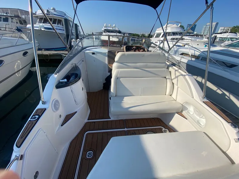 Slide: The Image of 2004 Regal 2665 Commodore boat interior with white seating and wooden flooring. - 10