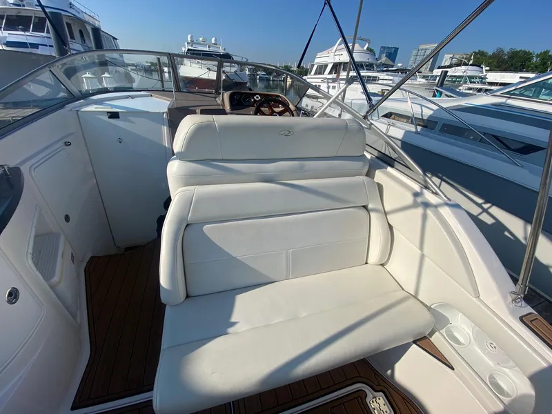 Slide: The Image of 2004 Regal 2665 Commodore boat interior with white seating and wooden flooring. - 11