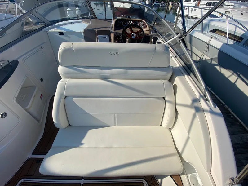 Slide: The Image of 2004 Regal 2665 Commodore boat interior with white seating and wooden accents. - 12