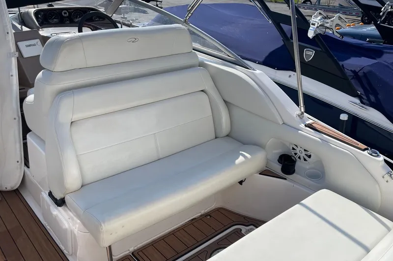 Slide: The Image of 2004 Regal Commodore 2665 boat interior with white seating and wooden flooring. - 13