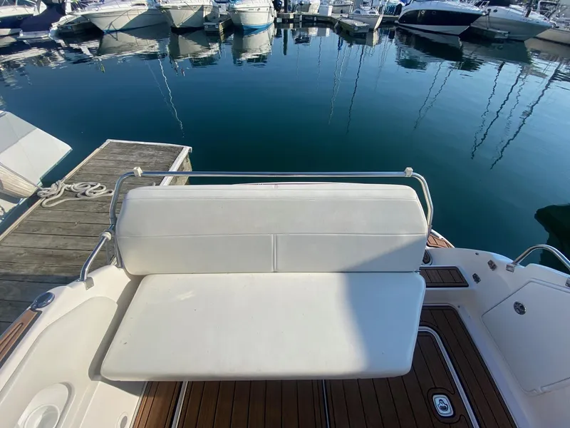 Slide: The Image of 2004 Regal 2665 Commodore boat with white seating at a marina. - 14